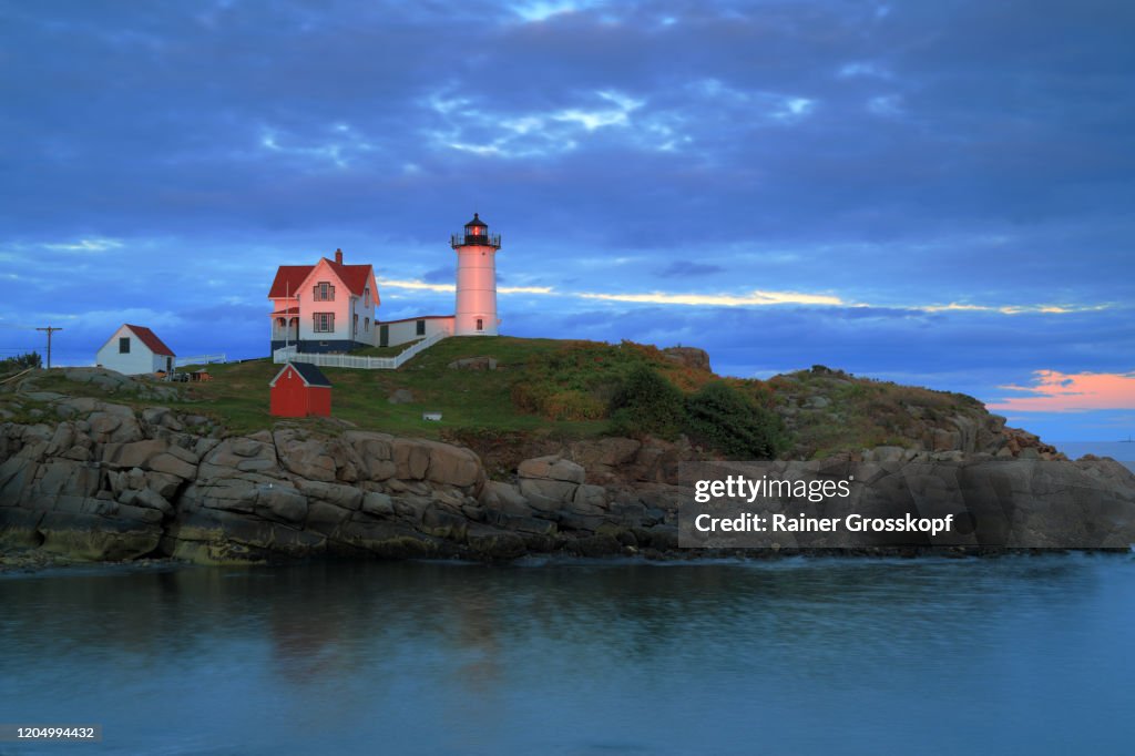 Little lighthouse on a small island at sunset