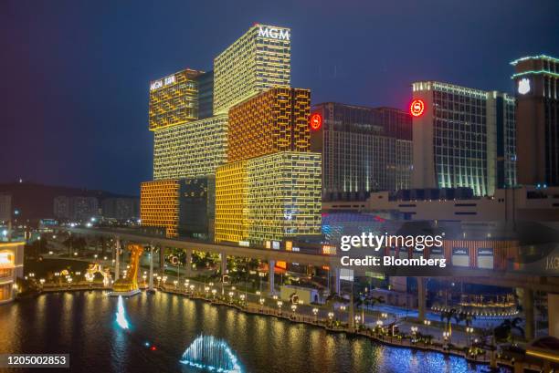 The MGM Grand Macau casino, developed by MGM China Holdings Ltd., left, stands illuminated at night in Macau, China, on Tuesday, March 3, 2020....