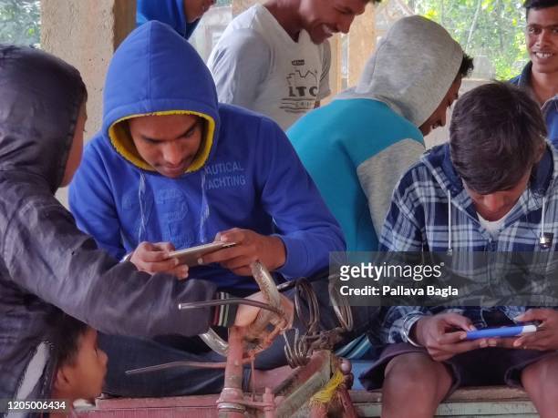 Oblivious of the surroundings this group of children indulge in online gaming sitting on broken down rickshaw. Children from the village of...