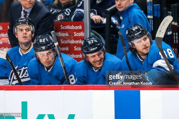 Nicholas Shore, Mason Appleton, Gabriel Bourque and Nathan Beaulieu of the Winnipeg Jets look on from the bench during third period action against...