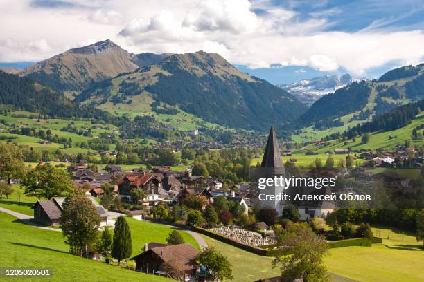 landscape near gstaad, summer view to saanen church and village - saanen stock pictures, royalty-free photos & images