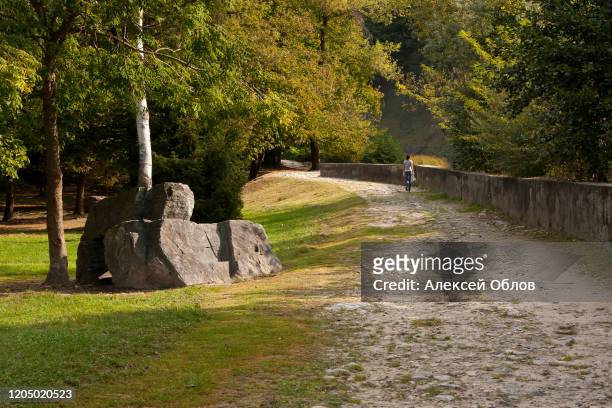 a girl walks along a path on a sunny autumn day in the valley of acquafraggia waterfalls in borgonuovo - valchiavenna, italy - acqua splash ストックフォトと画像