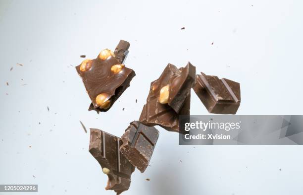 chocolate bar flying in mid air captured with high speed with white background - open chocolate bar stock pictures, royalty-free photos & images