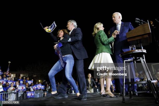 Former Vice President Joe Biden, 2020 Democratic presidential candidate, right, watches as his wife Jill Biden, second right, and staff members block...