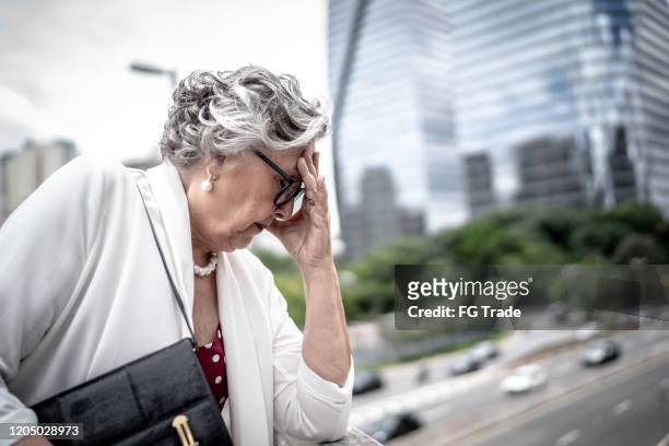 besorgt / hoffnungslose senior-geschäftsfrau an der brücke - kündigungsfrist stock-fotos und bilder