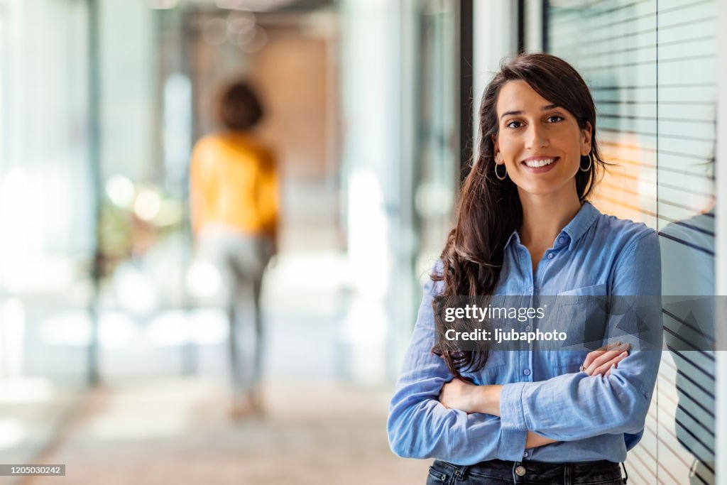 Jeune femme d’affaires mélangée de course souriant à l’appareil-photo