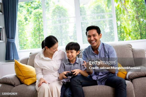 portrait of nice cute lovely attractive cheerful cheery positive funny people mom dad spending spare time attending contest winning in light white modern interior indoors - attending play stock pictures, royalty-free photos & images