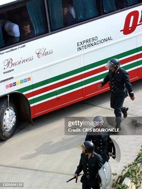 Players from the Ecuadorian soccer team observe Peruvian policemen while they arrive at the Monumental Stadium in Lima, 02 June 2001. Jugadores de la...