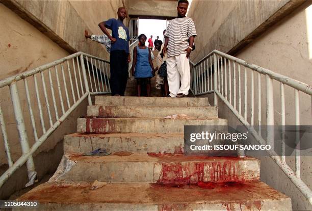 Residents look 10 May 2001 at pools of blood after a stampede at Accra's stadium which killed 123 people. The tragedy occurred after a 2-1 victory by...