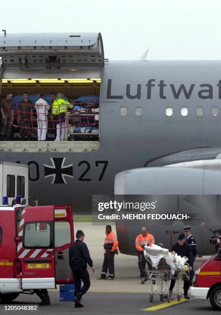 Les 12 blessés français sont transportés dans des ambulances, le 09 mai 2002, sur le tarmac de l'aéroport d'Orly. Blessés la veille dans...