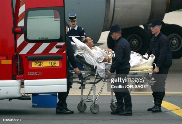 Un des 12 blessés français est transporté dans une ambulance, le 09 mai 2002, sur le tarmac de l'aéroport d'Orly. Blessés la veille dans...
