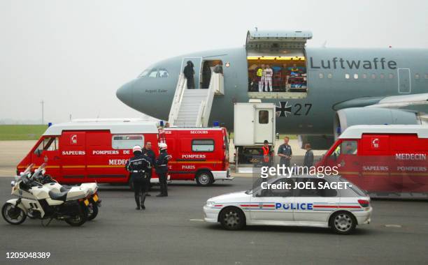 L'avion transportant 12 blessés français stationne près des véhicules de secours, le 09 mai 2002, sur le tarmac de l'aéroport d'Orly. Les 12 Français...