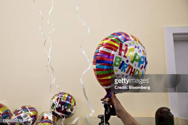 An employee fills a "Happy Birthday" balloon with helium at a Dollar Tree Inc. Store in Chicago, Illinois, U.S., on Tuesday, March 3, 2020. Dollar...