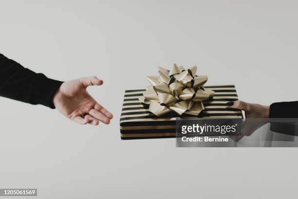 hand reaching to give gift with bow - wrapping arm stock pictures, royalty-free photos & images