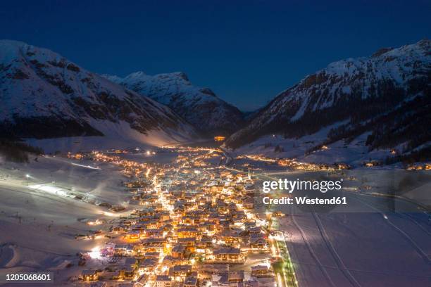 italy, province of sondrio, livigno, aerial view ofilluminatedtown in italian alps at dusk - livigno stock pictures, royalty-free photos & images