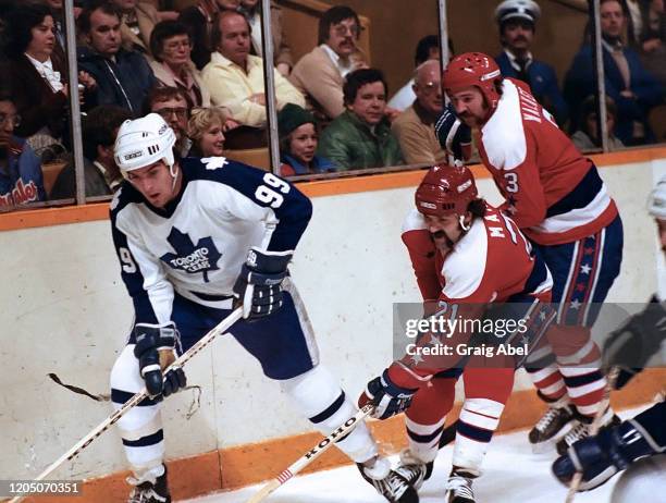 Howard Walker and Dennis Maruk of the Washington Capitals skate against Wilf Paiement of the Toronto Maple Leafs during NHL game action on November...