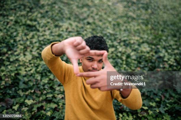 young man making a finger frame with his hands - finger frame stock pictures, royalty-free photos & images