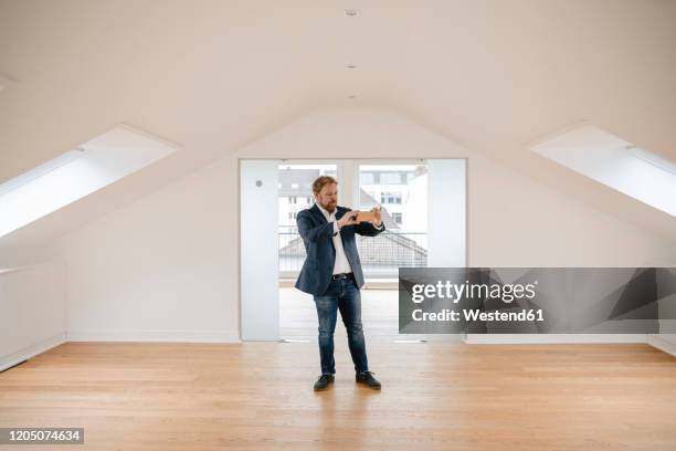 estate agent standing in empty apartement taking pictures - visie photos et images de collection