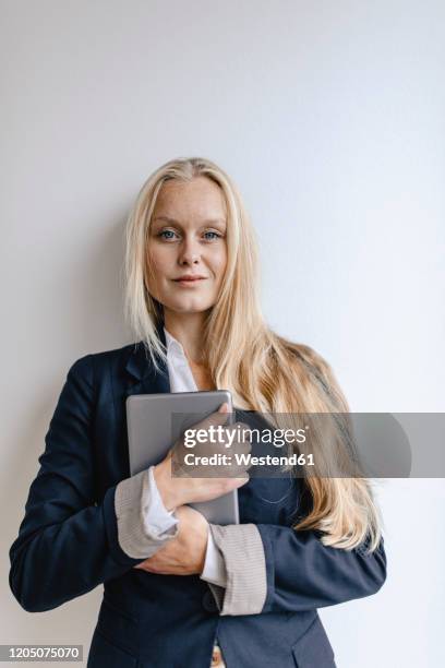 portrait of a blond young businesswoman holding tablet - arrogance stock pictures, royalty-free photos & images