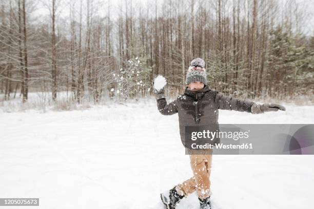 boy throwing snowball - bola de nieve fotografías e imágenes de stock