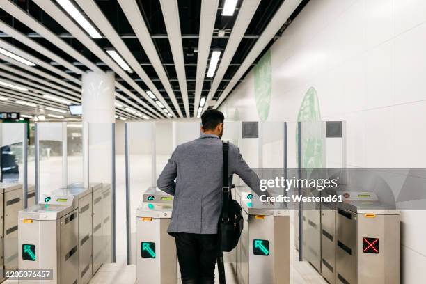 rear view of young businessman entering the subway station - gray coat foto e immagini stock