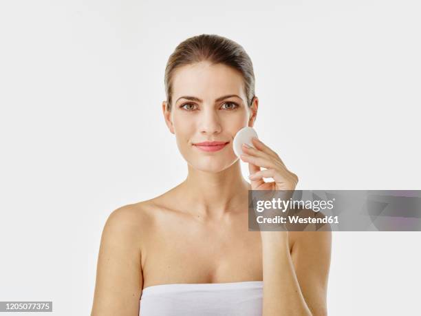 portrait of smiling woman cleaning face with cotton pad - shoulder pad 個照片及圖片檔