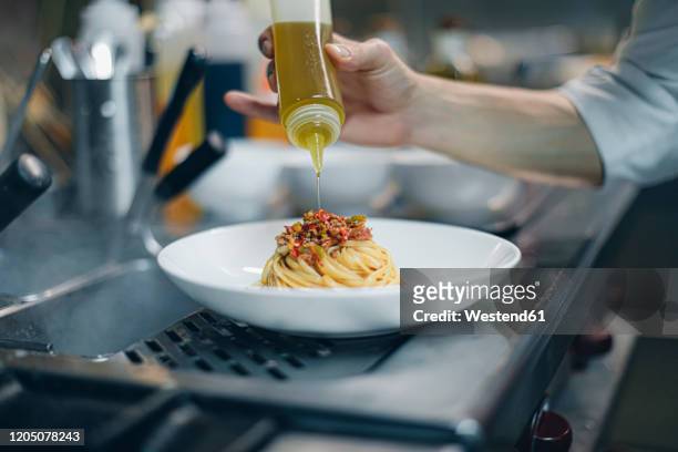 chef preparing a dish in traditional italian restaurant kitchen - accompagnement professionnel photos et images de collection