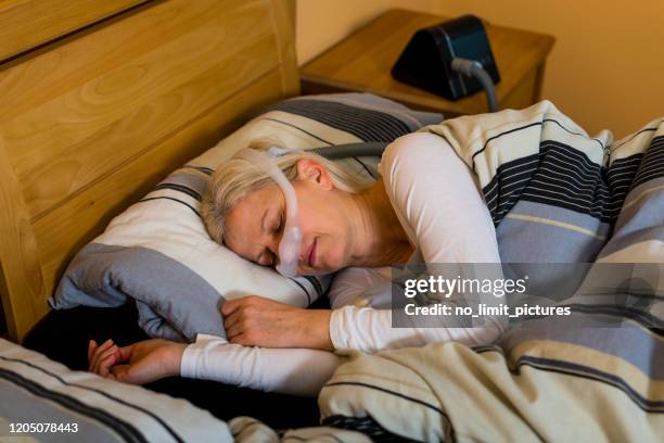 mulher dormindo com máscara cpap por causa de apneia obstrutiva do sono - nose mask - fotografias e filmes do acervo
