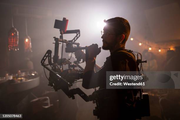 cameraman at work on movie set - filmkamera stock-fotos und bilder