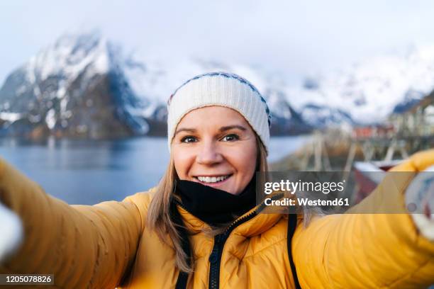 selfie of smiling tourist at hamnoy, lofoten, norway - blonde woman selfie foto e immagini stock