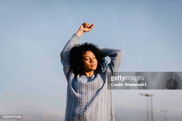 beautiful young woman outdoors under blue sky - blue sweater stockfoto's en -beelden