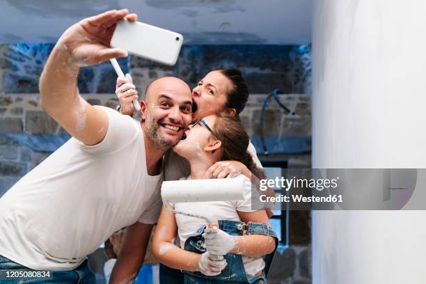 happy family taking a selfie while painting the walls of her new house - happy dirty child stockfoto's en -beelden