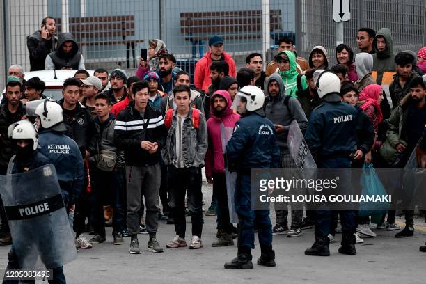 Greek anti-riot police gathers migrants and refugees from the Moria camp who stayed outside the port of Mytilene on the island of Lesbos, hoping to...
