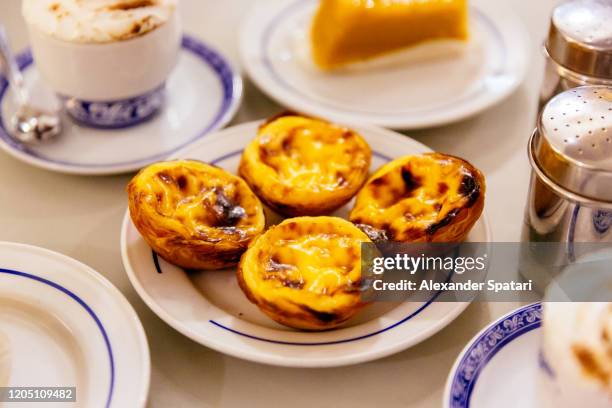 pasteis de nata, traditional portuguese pastry on a plate - portuguese culture fotografías e imágenes de stock