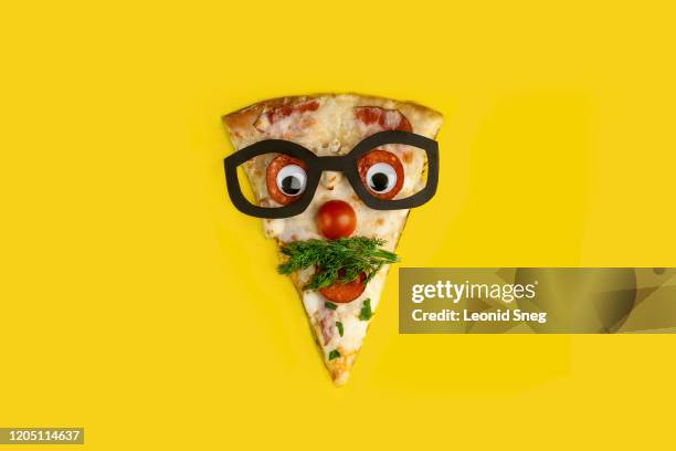 slice of pizza decorated as a surprised man in glasses on a yellow background - pizza humour stock pictures, royalty-free photos & images