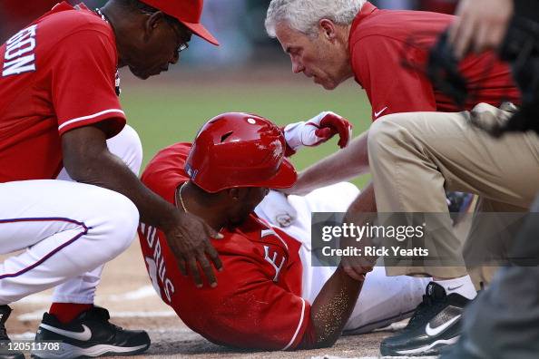 Ron Washington of the Texas Rangers and Jamie Reed help Elvis Andrus ...
