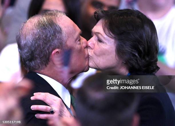 Former democratic presidential candidate and former New York City mayor Mike Bloomberg kisses his partner Diana Taylor in front of supporters and...