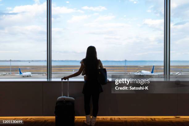 young woman looking at view from airport terminal - haneda stock pictures, royalty-free photos & images