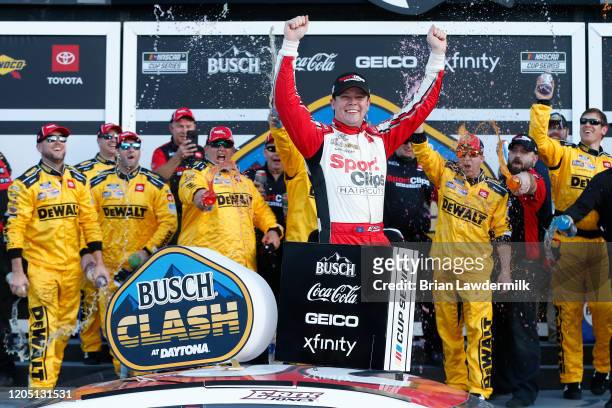 Erik Jones, driver of the Sport Clips Toyota, celebrates in Victory Lane after winning the NASCAR Cup Series Busch Clash at Daytona International...