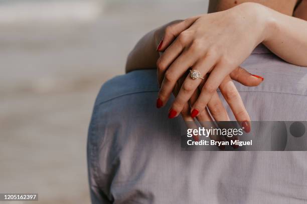 woman with red nails hugs man - heiratsantrag stock-fotos und bilder