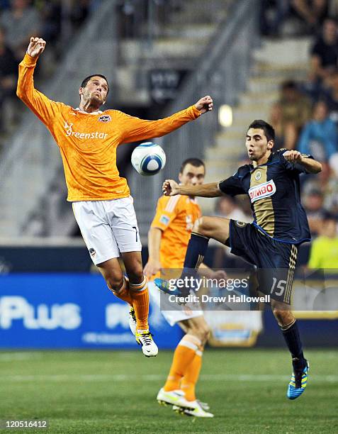 Colin Clark of the Houston Dynamo and Gabriel Farfan of the Philadelphia Union jump for the ball at PPL Park on August 6, 2011 in Chester,...