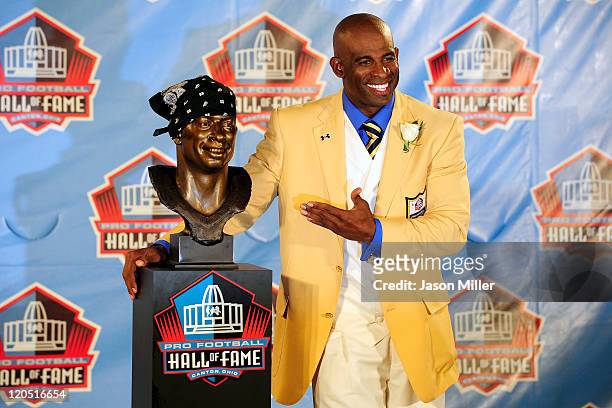 Former Atlanta Falcons cornerback Deion Sanders poses with his bust at the Enshrinement Ceremony for the Pro Football Hall of Fame on August 6, 2011...