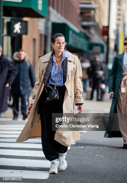 Lucy Chadwick is seen wearing striped button shirt, golden necklace, glasses, Chanel bag, trench coat, black pants outside Sies Marjan during New...