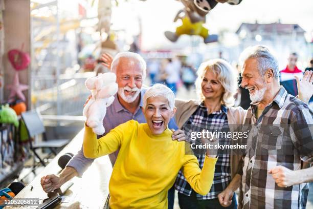 celebrating a victory at target shooting game! - old stuffed toy stock pictures, royalty-free photos & images