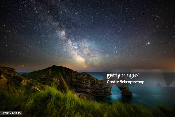 via láctea sobre durdle door at night - dorset uk - fotografias e filmes do acervo