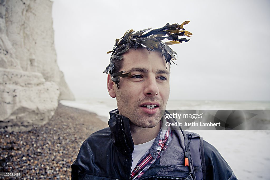 MAN PLAYS AROUND WITH SEAWEED ON HEAD
