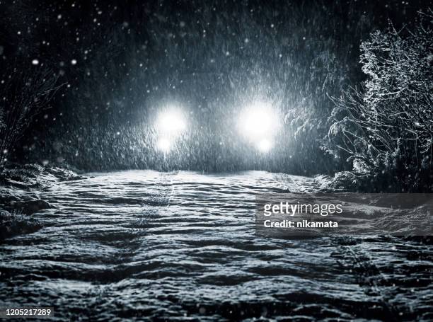 snow falls on the road in the headlights - car light trails stock pictures, royalty-free photos & images
