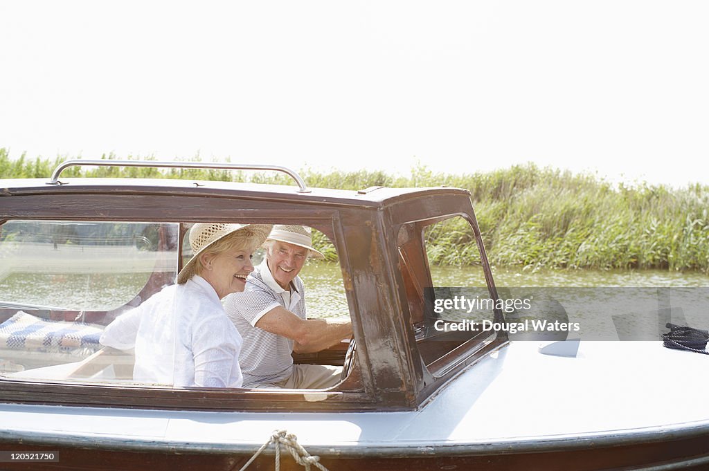 Senior couple in boat on river.