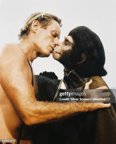 Charlton Heston , US actor, kissing Kim Hunter , who is dressed in an ape costumes, in a publicity still issued for the film, 'Planet of the Apes',...