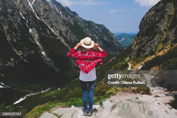 young woman in plaid shirt looks in mountains - tatra stock-fotos und bilder